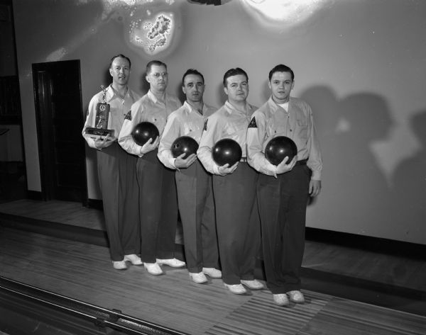 Group portrait of the Madison Brass Works championship bowling team. Team members are, left to right, Harry Vogts, sponsor, Harry Helman, Steve Caravello, Billy Dye, and Stan Thaden.