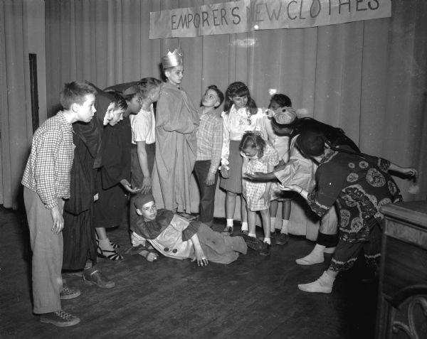 Sixth graders at Longfellow School presenting the children's story, "The Emperor's New Clothes." On stage, left to right, are: James Christensen, Floyd Di Modica, Darrell Dyer, Jacqueline Taliaferro, Rushton Johnson, Tony Parisi (as the emperor), Wilbert Ackerman, Ellen Fumuso, Sally Shore, Emma Jean Anderson, Clovis Johnson and Shirley Jackson (costumed), and Charles Beckwith as the jester at the emperor's feet.