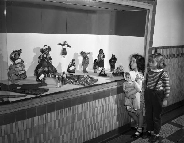 Two Washington school students looking at a doll collection belonging to Judy Maher that is on display at the school. The girls are Karen Love and Janice Joregenson, who are first graders.
