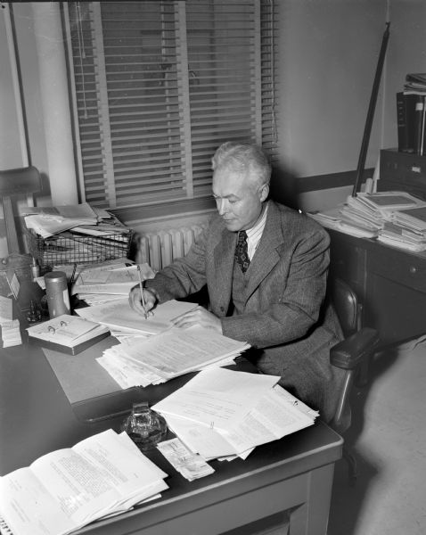 Louis F. Warrick, State Board of Health, at his desk.