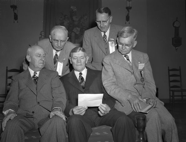 Members of the Madison Consistory gathered today at the Masonic temple for the 55th reunion. Otto H. Burmeister, veteran class guide, shows a telegram he received from Rep. Glenn R. Davis.
Seated left to right are: Benjamin H. Roderick, Brodhead; Burmeister, Middleton; W. Llewellyn Millar. Standing left to right are: Oscar Mueller and Noah J. Frey.