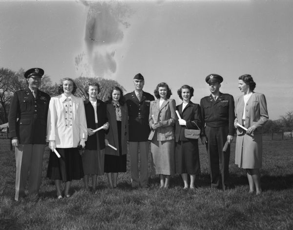 University of Wisconsin ROTC officers and military guests with the Military Ball Queen and her court. Left to right: Col. Wendell B. Fertig, Colorado School of Mines ROTC; Pattie Neilson, Milwaukee; Janet Williams, Kennilworth, Illinois; Mary Emig, Detroit, Michigan; Col. Howard J. Johns, University of Nebraska ROTC; Margaret Freeze, LaFarge; Queen Mary Schneiders, San Diego, California; Col. Willis Matthews, University of Wisconsin ROTC commanding officer, and Margie Kay Baer. Madison. The sixth member of the court, Mary Felton, Milwaukee, was not present.