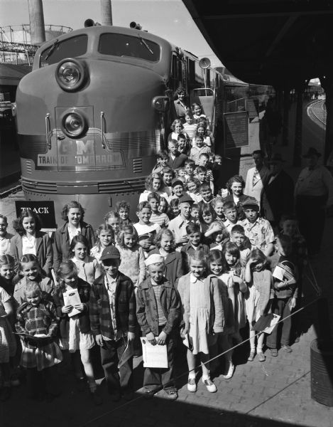 Youngsters from the Lakewood and Waunakee grade schools shown with the "Train of Tomorrow" at the North Western depot. The train was built for General Motors and embodies innovations expected to be found on trains of the future.