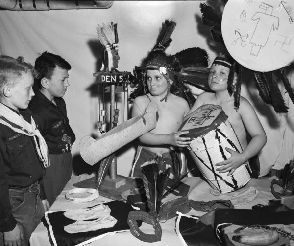 Members of Madison Cub Scouts Pack 309, Den 5, Lapham School, perform Indian dances for their parents, part of a project on Indian life and customs. Pictured left to right are: Philip Oren, Philip Blankenship, Don Heilinger, and Philip Anderson, the latter two boys in Indian costume.