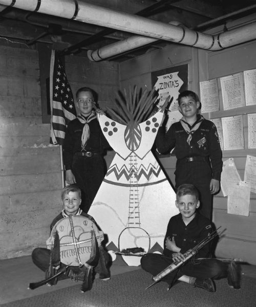 Members of Madison Cub Scout Pack 309, Den 5, Lapham School, pictured with their handiwork developed for their Indian tribe project which includes a teepee, shield and quiver of arrows. Seated left to right: Dick Hustad and Neil Godfriaux. Standing left to right: Tom Holm and Bob Gruber.