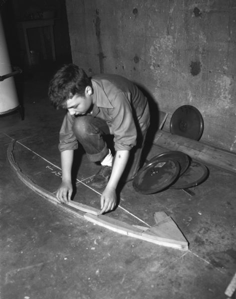Roddy Botts, son of Mr. and Mrs. R. Chellis Botts, shown adding a small piece of wood to the body of his 1948 racer. He had the most original design in the 1947 Soap Box Derby.