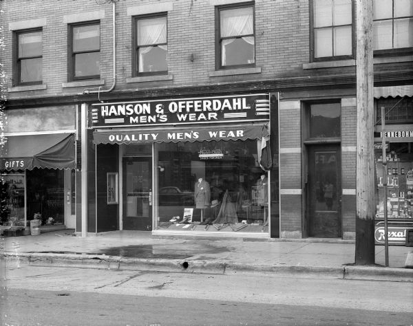 View from across street of the storefront of Hanson & Offerdahl Men's Wear store, 1961 Winnebago Street, Madison's newest men's shop, taken on the occasion of its grand opening.