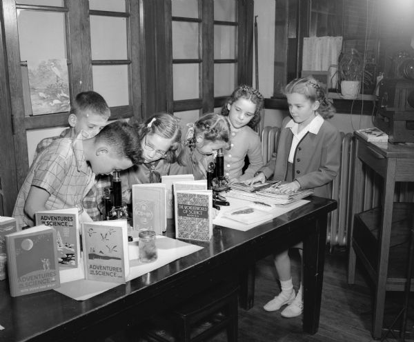Fourth graders at Emerson Elementary School, 2421 East Johnson Street, shown using microscopes in the school's science room. Left to right: David Meng, Tom Hundlay, Gail Smith, Judy Tucker, Ruth Davidson, and Mary Edmund.