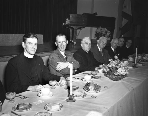 Knights of Columbus speakers table for the dinner honoring five long-time members are: left to right, Reverend Jerome Mersberger, St. Bernard's Church; Allen J. McAndrews, toastmaster; Reverend Francis L. McDonnell, Our Lady Queen of Peace; Dr. C.W. Henney, Portage, supreme director of the Knights of Columbus in Wisconsin, and William A. Devine, a charter members of the Madison Council.