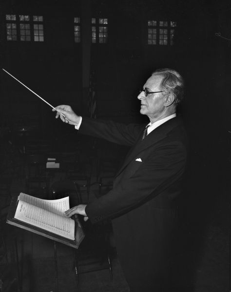 Dr. Sigfrid Prager conducting the Madison Civic Symphony Orchestra, the Madison Civic Chorus, the University of Wisconsin chorus and soloists in his farewell concert, held at the University of Wisconsin-Madison Stock Pavilion. Dr. Prager was the conductor of the civic groups for twenty-one years.