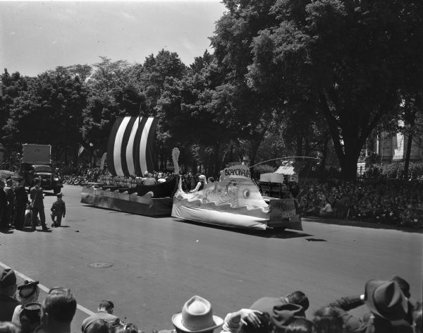 Wisconsin Centennial Parade near the Wisconsin State Capitol. A float of a Viking ship is being pulled by a vehicle decorated as a fish, "the Spirit of Scandinavia."