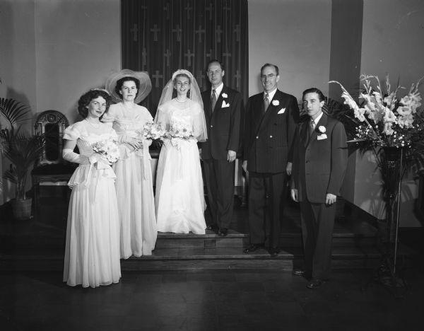 Jeanne Remus, bride, and DeAlton Neher, groom, pictured with their attendants in the chapel of the First Congregational Church. Groomsmen are William G. Harley and Franklin Cook, both from Madison. Bridesmaids are Mrs. Milton Farber, Weyauwega and Carol Vanderhoff, Beaver Dam. Both the bride and groom as well as the groomsmen are employed in the radio industry.