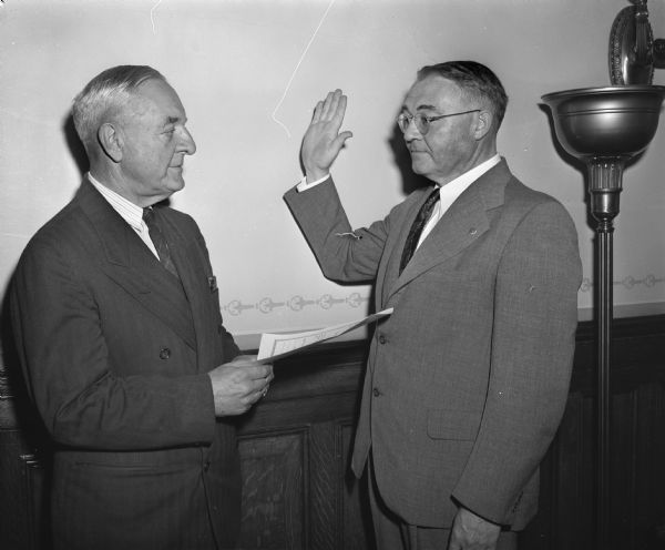 Wisconsin Supreme Court Justice Elmer Barlow, left, administering the oath of office to Grover Broadfoot,(1892-1962) the new attorney general for Wisconsin.