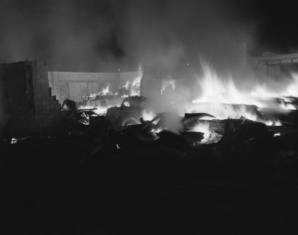 The lumber and appliance building of the Central Wisconsin Supply Company is engulfed in flames, which totally destroyed the building.