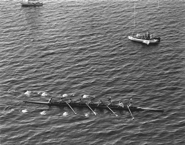 The California varsity crew is shown defeating the Wisconsin varsity crew. The finish judge and boat are shown in the upper right. The elevated view was taken from the roof of the Edgewater hotel.