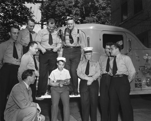 Several members of Local 311, Madison Firemen's union, are posed around Dick Lerwick, whom the union is sponsoring in the 1948 Soap Box Derby.  Kneeling Edward Bokina, union president. First row L to R: Fireman Joe Tisserand, Dick, Capt. Arne Lerwick, Dick's father, and Firemen Fred Rice and Pete Breitenbach.  Rear row L to R: Firemen Maruice Nason, Wilson Donkle, and Harlan Lippolt, and Lieut. Grover Peterson.