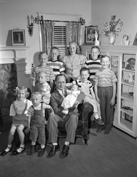 Group portrait of Paul G. Ryan, 2913 Winnequah Road, shown with his ten children. Seated in front row left to right: Mary Jo, 6; James, 2; Mr. Ryan holding Judith Ann, 3 weeks; Daniel, 3 1/2, and Michael, 5. Standing from left to right: Paul, Jr., 9; Cornelius, 11; Nancy, 12; Theodore, 10, and Patrick, 7.