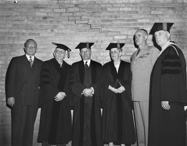 Six distinguished guests of the University of Wisconsin-Madison are shown as they attended commencement ceremonies at the Field House. Left to right: Gov. Oscar Rennebohm; Warren Weaver, New York; Harold Falk, Milwaukee; Alice Evans, Chevy Chase, Maryland; Gen. Omar Bradley, army chief of staff; and Pres. E.B. Fred of the University. Weaver, Falk, Evans and Bradley all received honorary degrees.