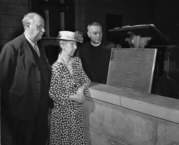 Clarence Lester, Mrs. Arthur (Agnes) Peabody, and the Reverend Edward Potter Sabin, admiring a bronze memorial plaque commemorating the first vestry and founders of St. Andrew's Episcopal Church, 1833 Regent Street.



