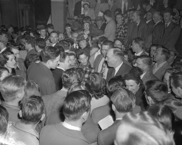Republican presidential candidate Harold E. Stassen surrounded by the crowd following his speech at the University of Wisconsin-Madison Stock Pavilion.