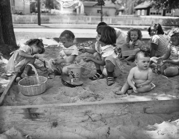 Playing in the sandbox at Olbrich Park are Mary Lou Whitney, Ann Spilde, Patsy White, year-old Noreen Kay Morehouse and some playmates.