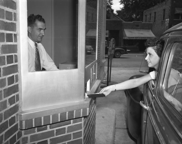 Maxine Hanson, 133 Talmadge Street, making a deposit from her car at Security State Bank's new drive-in deposit window at 1965 Atwood Avenue. The teller is Carl Anderson.