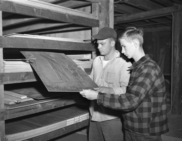 Yardman Don Hoffman helps Bill Morton pick out plywood for his soap box racer at C.C. Colling Lumber Yard on University Avenue.