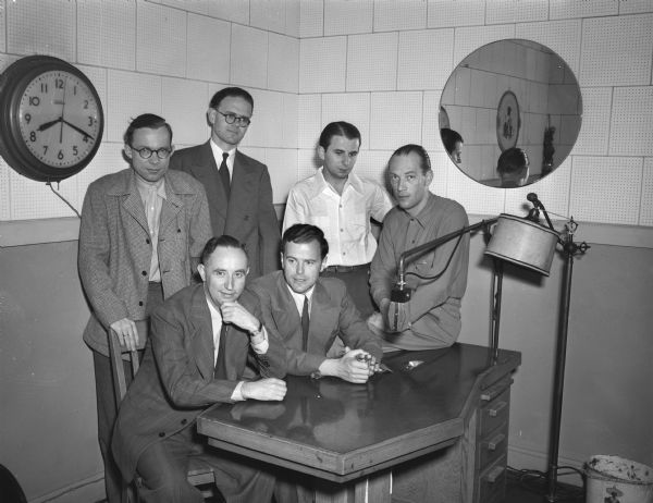 Group portrait of six German radiomen from the Western Allies' zone visiting WHA, the University of Wisconsin-Madison radio station. The group was in Madison to study newspaper and radio procedures.