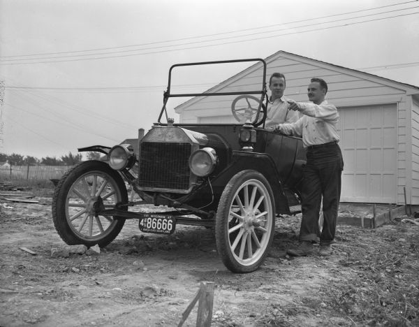 Tom Reese and Raleigh Williams, juniors at the University of Wisconsin-Madison, with their 1913 Ford car which they plan to drive to Milwaukee for the State Centennial antique car contest.