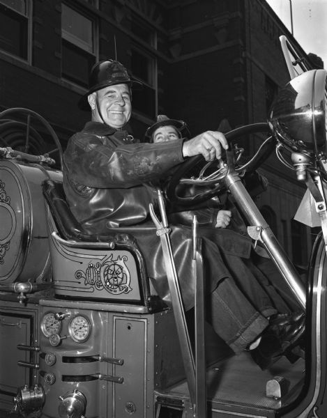 Close-up of Fireman John Hoffman at the wheel of a 1929 pumper truck which is going to be "retired".