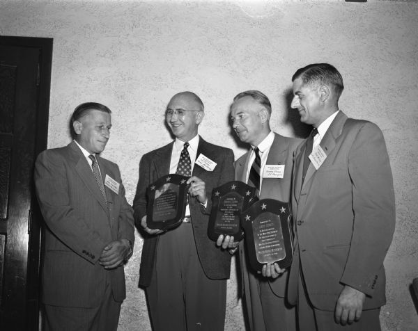 Louis Heindel (left), Madison Business Association president, presented plaques to Edwin J. Connor, Emery Oliver, and Louis Hirsig in recognition of outstanding service to the community and to the association. Stanley Kubly (extreme right) a business associate of Hirsig, accepted the plaque on Hirsig's behalf.