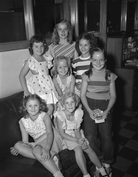 Group portrait of seven girls who put on an entertainment on Kendall Avenue, which raised $8.10 for the Ballweg family hit hard by the tornado that recently ravaged Springfield Hill. Left to right seated:  Mary Neff and Terry Turner. Behind them are Joan Dornfeld, Mary Alice Dobson, Mary Carol Aageson and Nancy Neff. In the back is Ann Aageson.