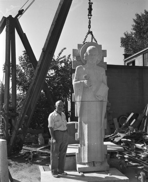 Sculptor Stefan Mittler, posed with an 11 feet 6 inch tall statue of St. Peter at his monument works at 29 N. Orchard Street. The statue was intended for New Haven, Iowa's newly built Catholic church, St. Peters.