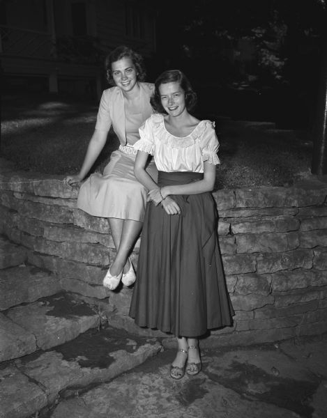 Two young co-eds from Maple Bluff, soon to leave for their universities. Pictured sitting on a stone retaining wall outside are from the left: Janet Huiskamp, Leland Stanford University, Palo Alto, California; Susan Anderson, Radcliffe College, Cambridge, Massachusetts.