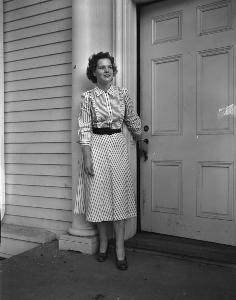 Eve Bloodgood, standing outside the front door of her parents house at 1102 Lincoln Street, soon to leave for her senior year at Kemper Hall, Kenosha, where she was elected head of the student body.