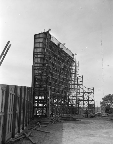 Scaffolding set up for the construction of a screen for the Badger Outdoor Theater. The photograph was taken for the Safway Steel Scaffolds Company, 940 Williamson Street.