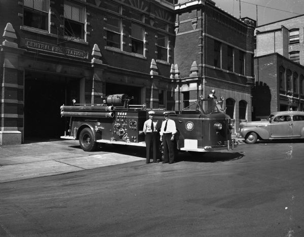 Fire Chief Edward J. Page (right) and Lieut. Albert Rogg standing next to one of three new Madison fire truck at the Central Fire Station, 18-20 South Webster Street.