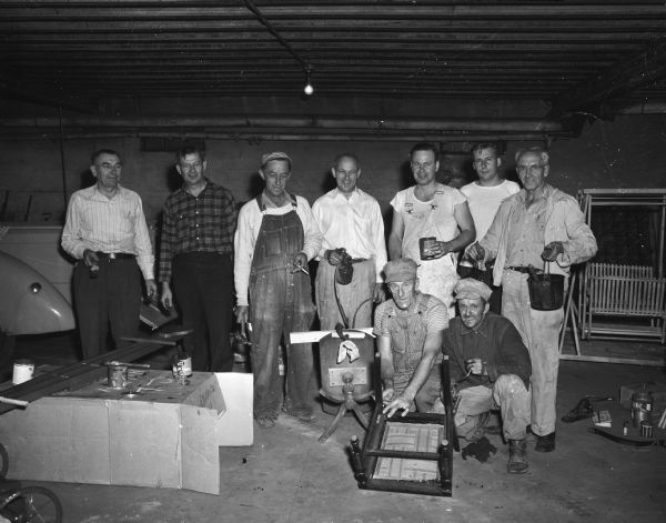 The repair and conditioning committee of the West Side Business Men's Association that was in charge of preparing the auction site for the sale to benefit the building fund for a new club house and recreation center. Kneeling are Hi Nelson, left, and Al Crossman. Standing, left to right, are Henry Simon, H.C. Weiss, William Statz, L.J. Padgham, Paul Mills, Harland Klipstein, and George Whitmore.
