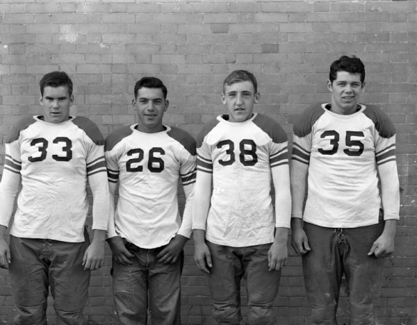 Portrait of four Wisconsin High School football players in uniform.
