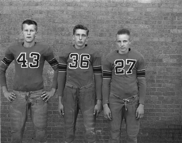 Portrait of three Central High School football players in uniform.