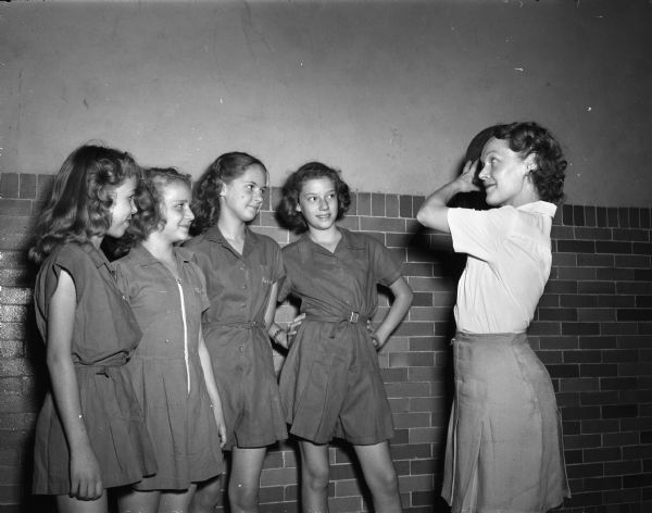 Vera Pay, right, exchange teacher from London, England, is shown instructing four Emerson school physical education 6th grade girls who are wearing gym clothes. They are, left to right: Nancy Day, Carol Bryan, Mary Ann Russel and Donna Ashard.
