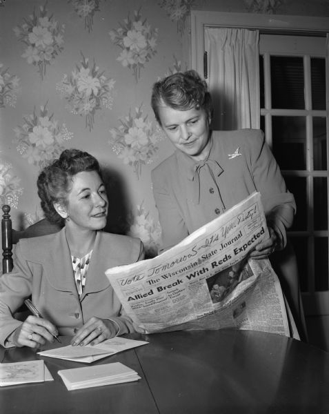 Mrs. Lester W. (Dorothy) Paul, 3220 Topping Road, at left, and Mrs. Lloyd W. (Mildred) Coleman, 1123 Oak Way, at right, perusing the birth column in the <i>Wisconsin State Journal</i> to see if any Shorewood Hills residents had new babies. The two women are members of the Shorewood Hills Community League hospitality committee.