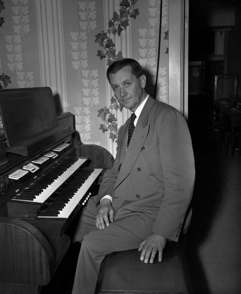 Original caption reads: "Back in Madison after 27 years is Richard Neumann, one-time organist at the Orpheum and Parkway theaters. Neumann was the organist at the 1936 Olymic games in Berlin." He also worked with composer Richard Strauss twice, once in 1920 at Madison's Parkway Theater and once at the 1936 Olympics in Berlin.
