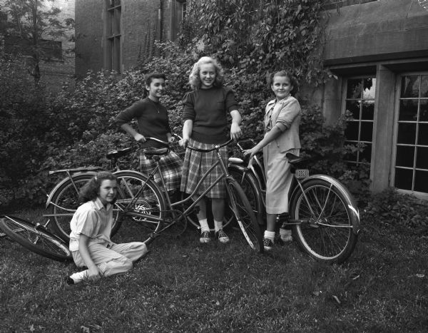 Four members of the Junior Y Teen group with their bicycles prior to starting out on a "bicycle hike" and picnic. Shown left to right: Charlotte McVicar, 724 Conklin Place; Mae Wein, 525 West Johnson Street; Donna Feggestad, 213 North Mills Street; and Betty Black, 712 West Dayton Street.