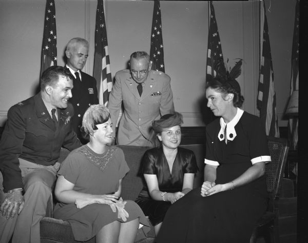 University of Wisconsin Military and Naval Reserve Officer Training Corps (ROTC) commanding officers and their wives at a fall social party held in their honor at the Hotel Loraine. Pictured standing from left to right are: Naval ROTC Commandant, Capt. J.E. Hurff; Military ROTC Commandant Col. Carl E. Lundquist; Brig. Gen. John Mullen, state adjutant general who represented the Wisconsin National Guard at the party. Seated, from left to right, are the officers' wives: Mrs. Lundquist; Mrs. Mullen; and Mrs. Erick B. Hurff.