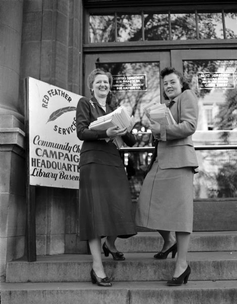 Madison Community Chest campaign women's division chairman, Mrs. Paul Knaplund (left) and her co-chairman, Mrs. T.C. (Emily) Erickson at entrance to the campaign headquarters in the city library.