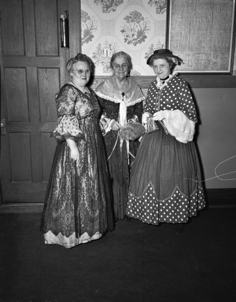 Three women in historic costumes posed at Wisconsin Federation of Women's Clubs Wisconsin Centennial Tea Party held at the Woman's Building. They are let to right: (Mrs. Leonard) Fay Howell, (Mrs. Leon L.) Gertrude North and (Mrs. Edwin B.)Rosa Fred.
