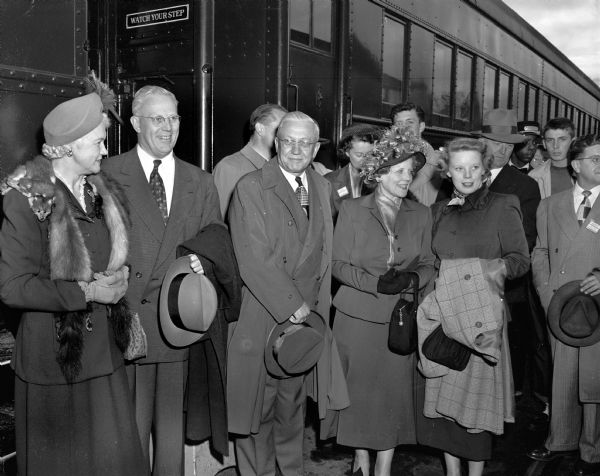 People involved in the Earl Warren United States vice-presidential campaign standing in front of the campaign train shortly after its arrival at the railroad station. Pictured from left to right are: Mrs. Oscar (Mary) Rennebohm; California Governor Earl Warren; Mrs. Warren; and Virginia Warren, the candidate's daughter.