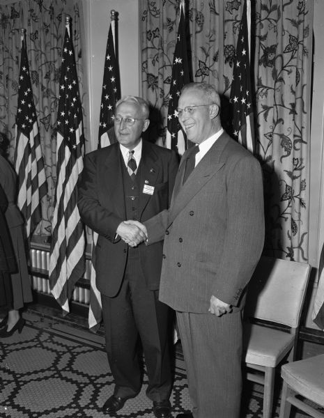 Harvey Higley, left, chairman of the state Republican voluntary committee, shakes hands with United States vice-presidential candidate Earl Warren at a reception held at the Hotel Loraine soon after the Warren train arrived.