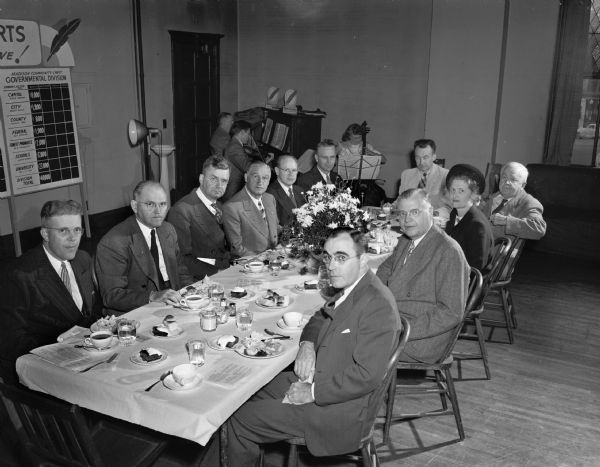 The Madison Community Chest campaign kick-off luncheon at Grace Episcopal Church. Shown at the speakers table, clockwise from the left are: F. Halsey Kraege, president of the Madison and Wisconsin Foundation; E.L. Wingert, president of the Community Union; Joseph R. Rothschild, 1947 campaign chairman; John E. Canfield, 1948 campaign chairman; Joseph G. Werner, business and industrial gift division chairman; Dr. Llewellyn Cole, co-chairman of the University of Wisconsin subdivision of the government division; Dr. E.B. Gordon, emeritus professor of music of the University of Wisconsin; Mrs. Paul Knaplund, women's division chairman; Alan C. Hackworthy, advance gifts division chairman; and  J.J. Keliher auditing committee chairman.
